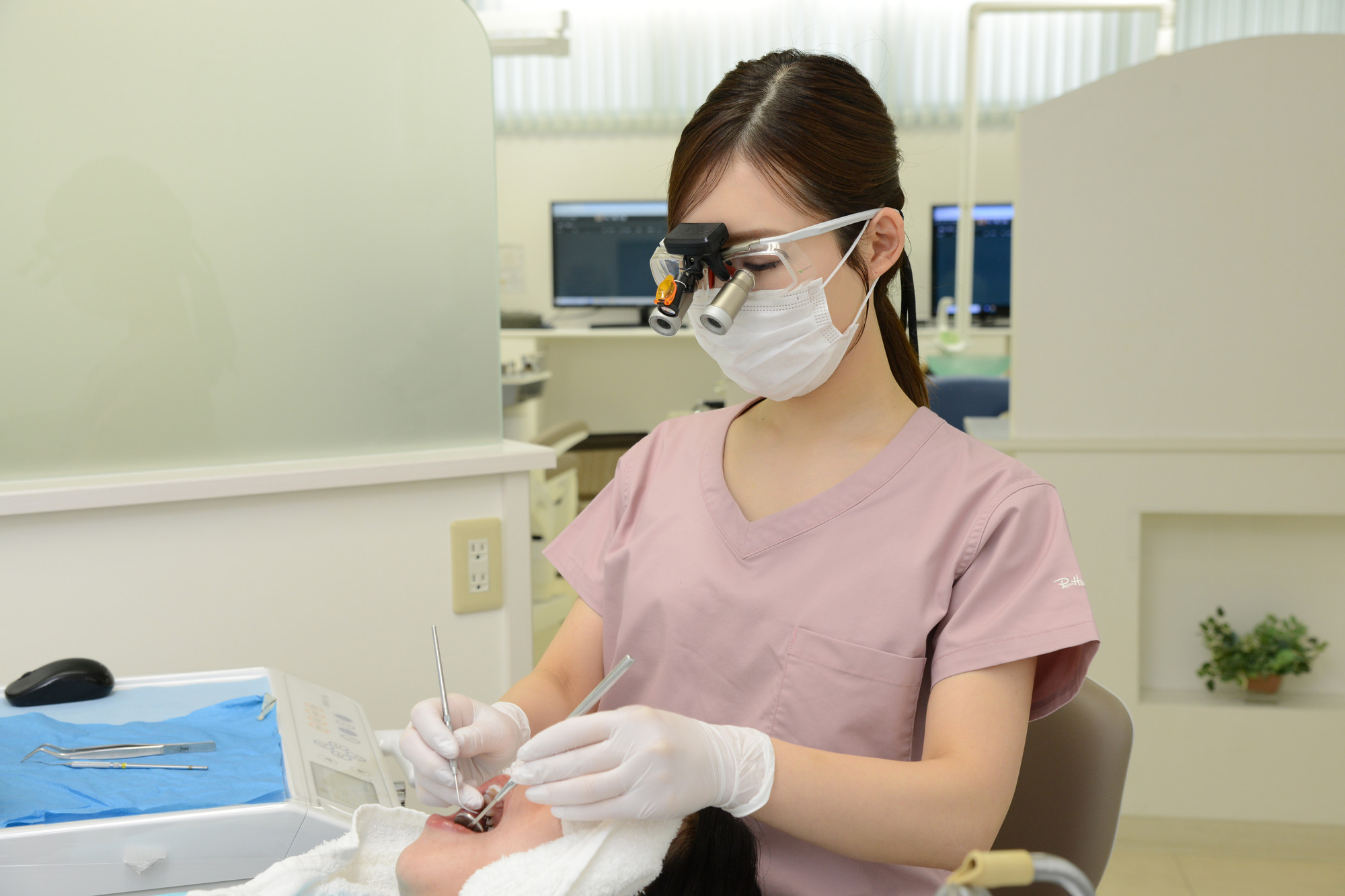 歯科用拡大鏡を装着して治療している歯科医師の村田紗也子